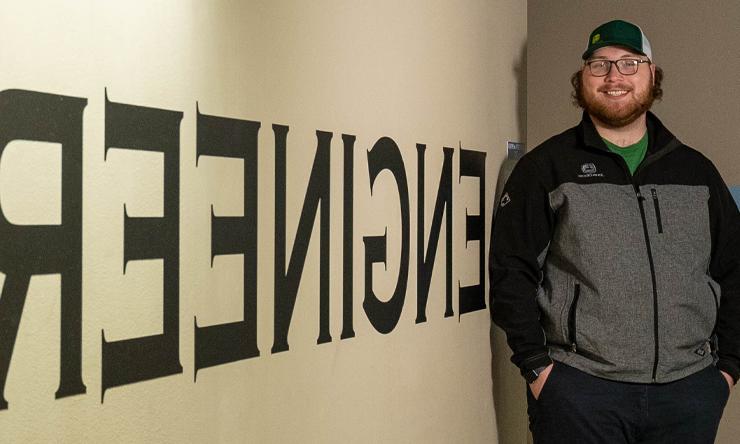 Caleb Harrison standing beside the engineering sign